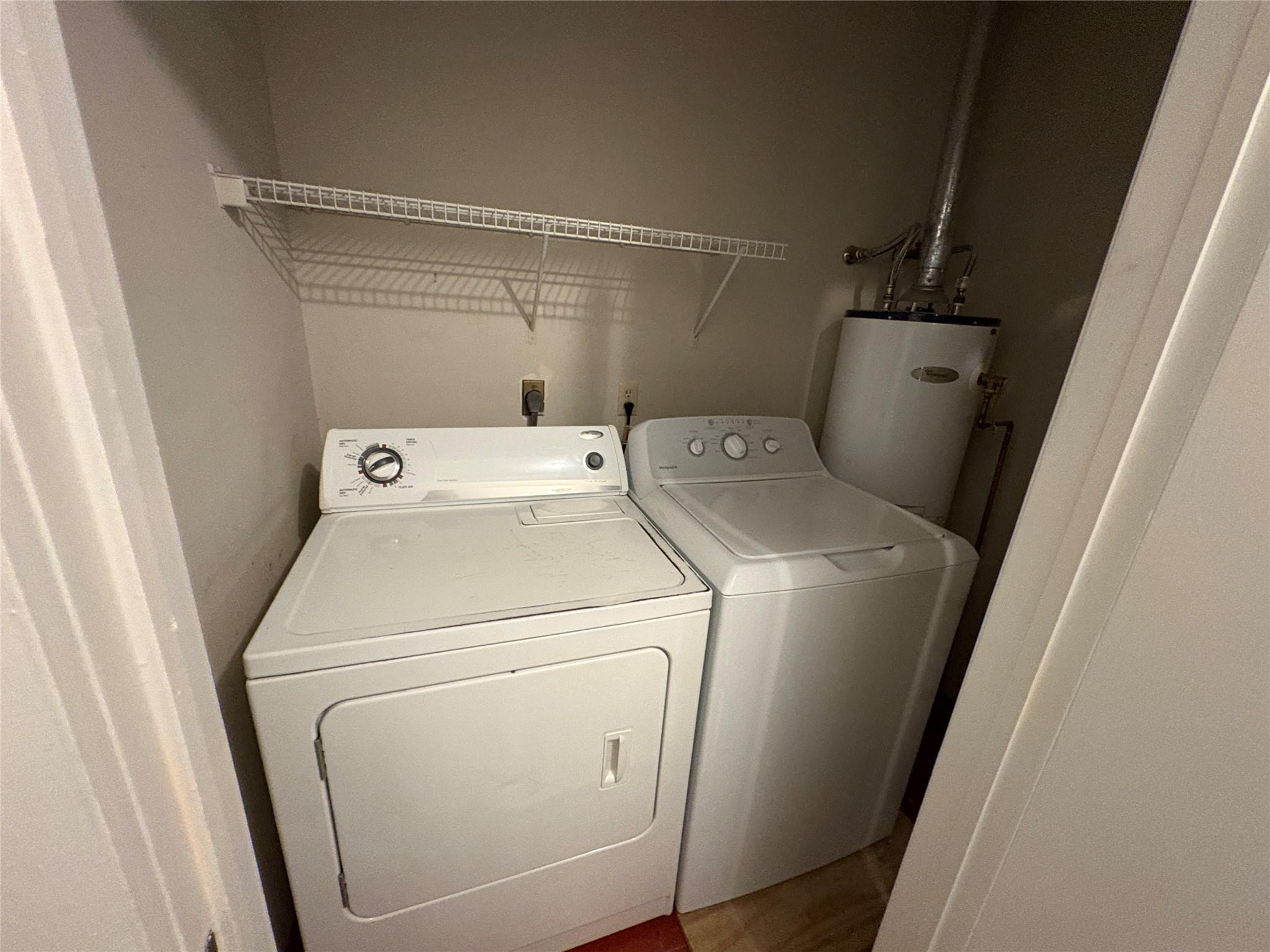 915 West 29th Street Austin, TX 78705 - Photo 14 of 20 Dedicated laundry area featuring a white washing machine and dryer, overhead wire shelving, and a water heater