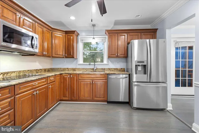 a kitchen with stainless steel appliances granite countertop a refrigerator a stove top oven a sink and dishwasher