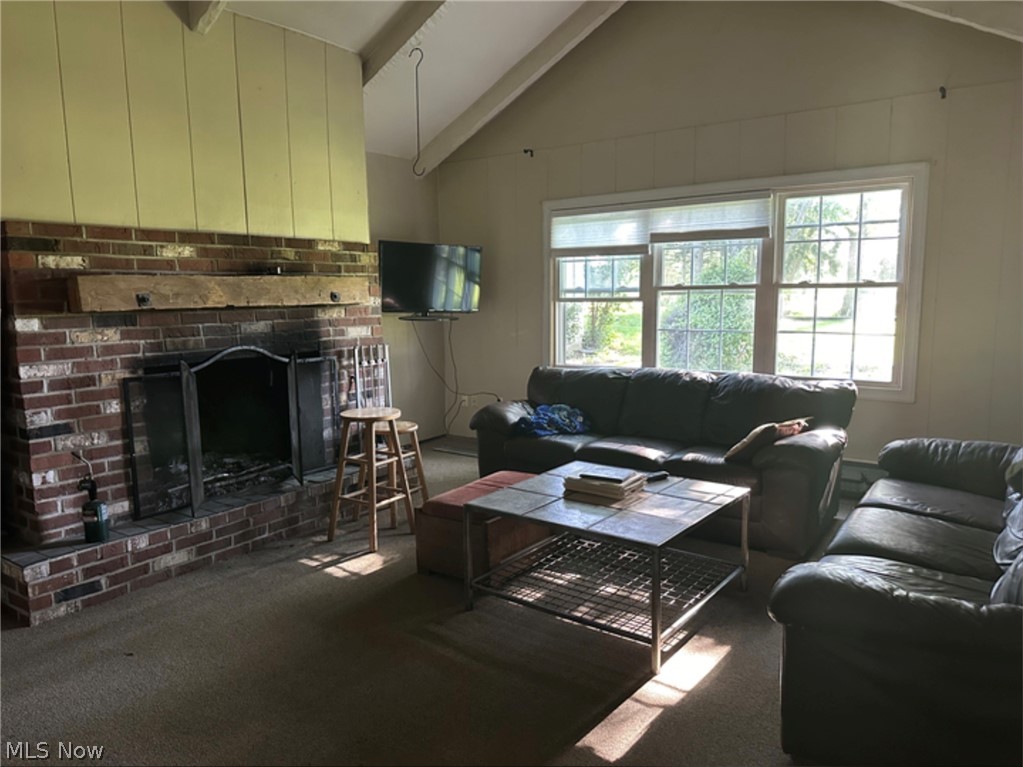 10970 Durkee Road Grafton, OH 44044 - Photo 2 of 9 Living area featuring a brick fireplace with a wood mantle, vaulted ceilings, and large windows