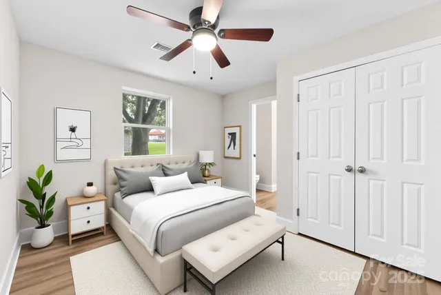 a bedroom with a large bed and a chandelier