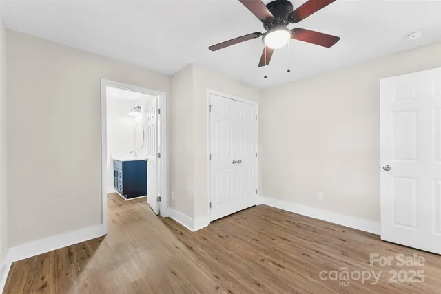 an empty room with wooden floor a ceiling fan and closet