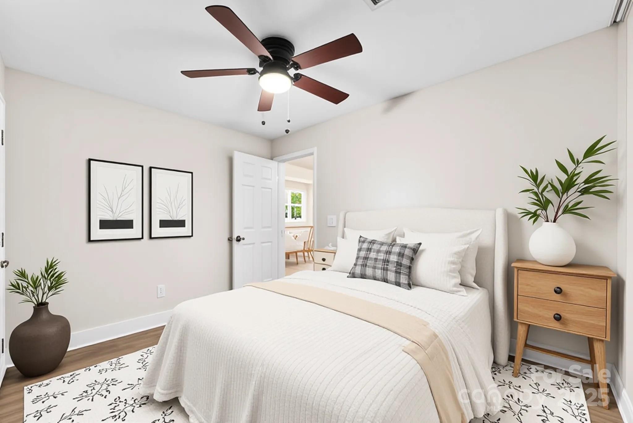 601 Rhyne Circle, Unit B Gastonia, NC 28054 - Photo 15 of 32 a bedroom with a bed a chandelier and a potted plant