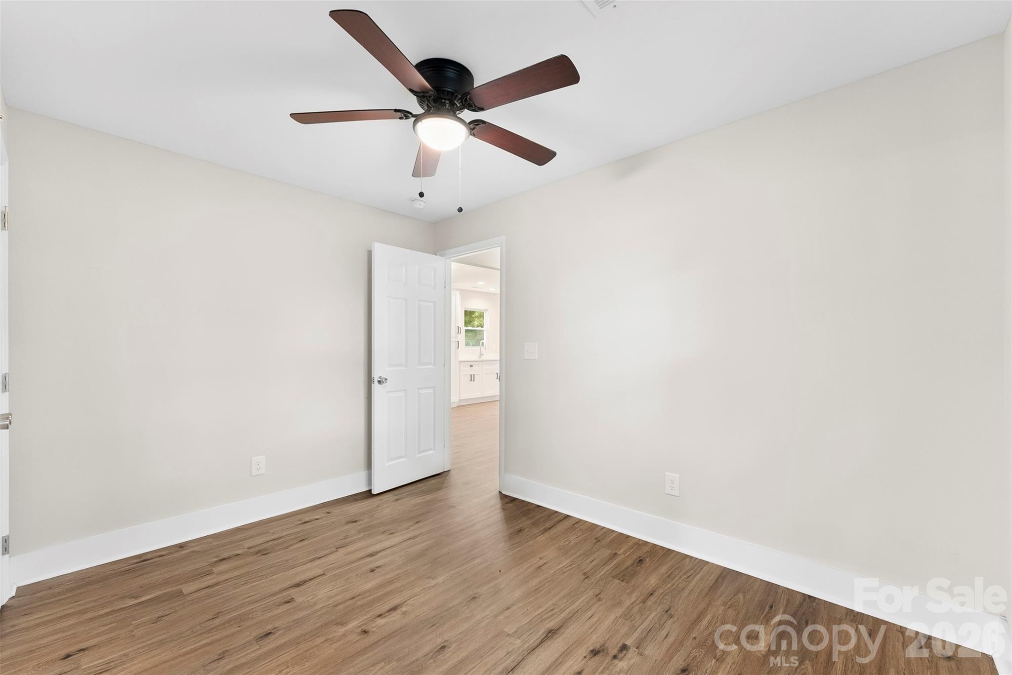 601 Rhyne Circle, Unit B Gastonia, NC 28054 - Photo 16 of 32 an empty room with wooden floor and ceiling fan
