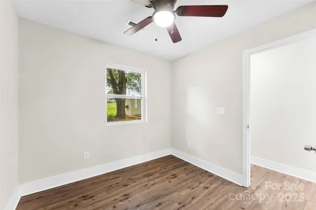 a view of empty room with wooden floor