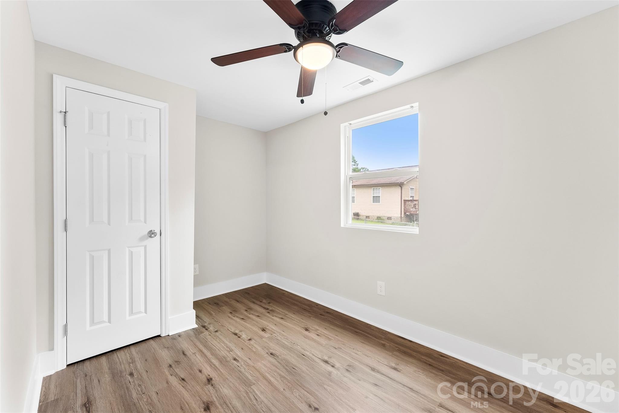 601 Rhyne Circle, Unit B Gastonia, NC 28054 - Photo 25 of 32 an empty room with wooden floor a ceiling fan and a ceiling fan
