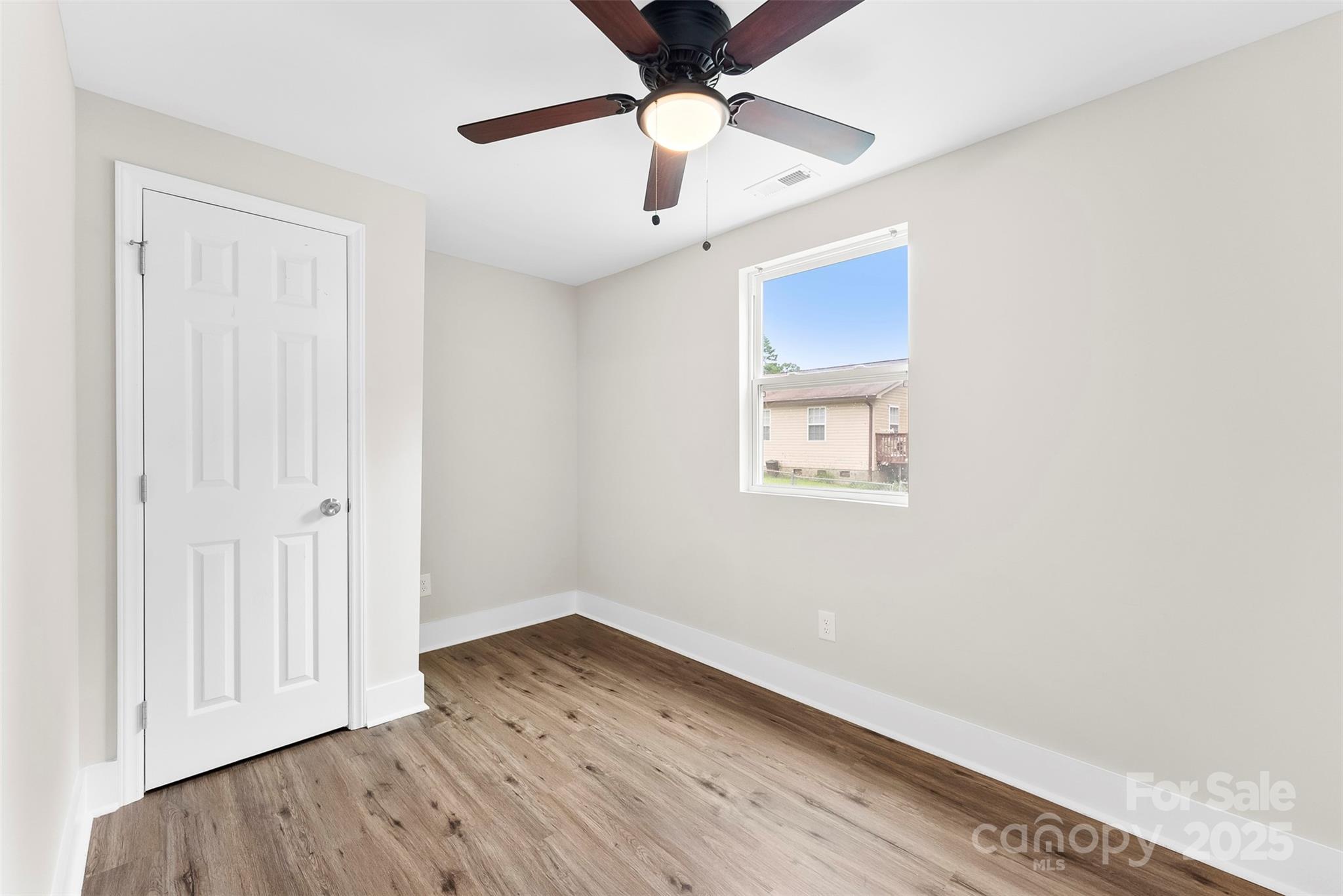 601 Rhyne Circle, Unit B Gastonia, NC 28054 - Photo 25 of 32 an empty room with wooden floor a ceiling fan and a ceiling fan