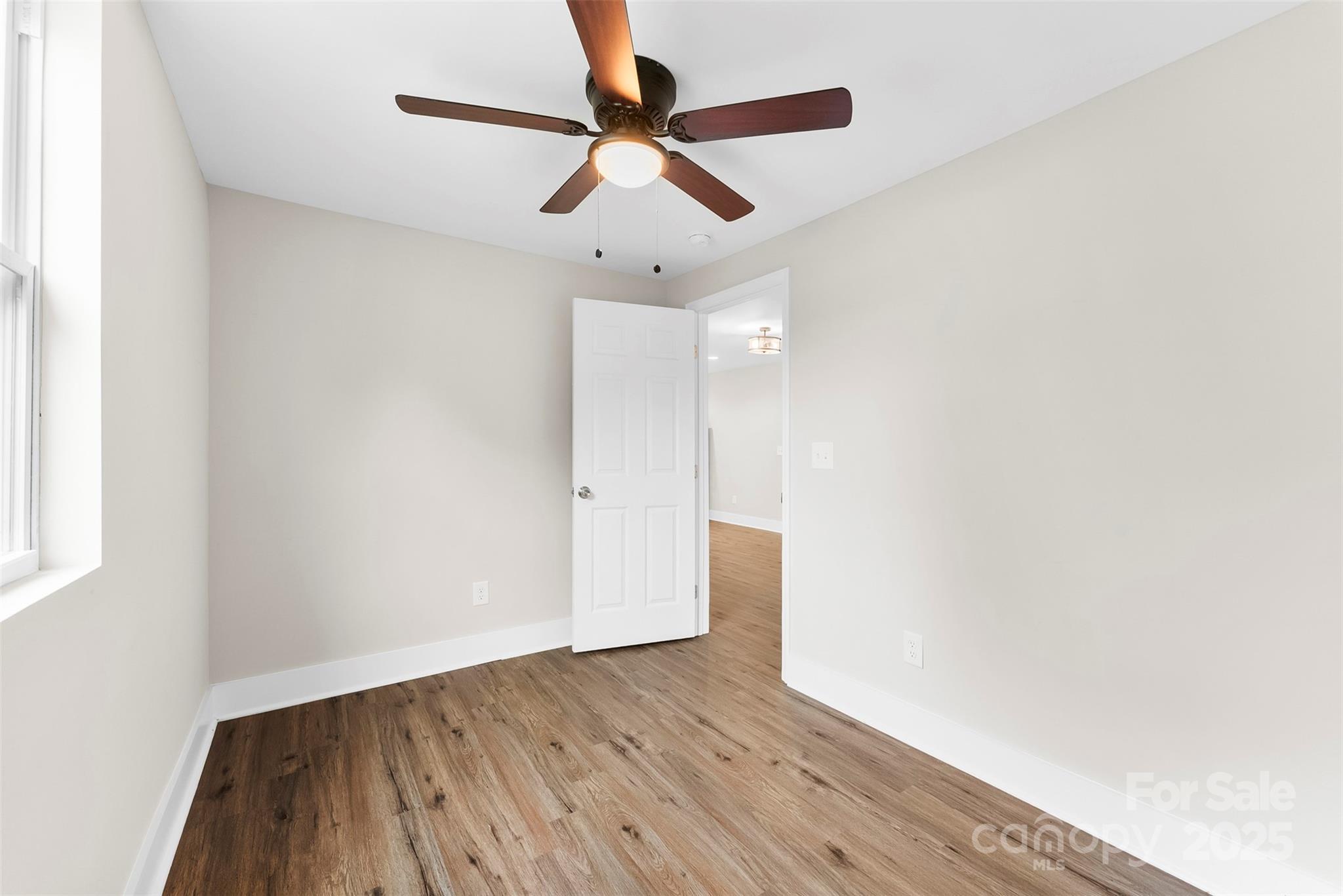 601 Rhyne Circle, Unit B Gastonia, NC 28054 - Photo 27 of 32 an empty room with wooden floor ceiling fan and window