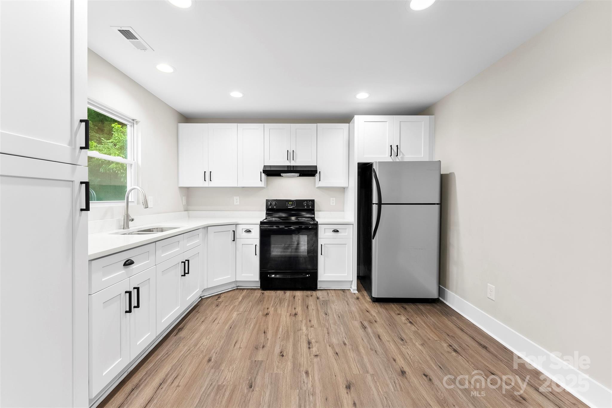 601 Rhyne Circle, Unit B Gastonia, NC 28054 - Photo 9 of 32 a kitchen with granite countertop a refrigerator oven a sink dishwasher and white cabinets with wooden floor