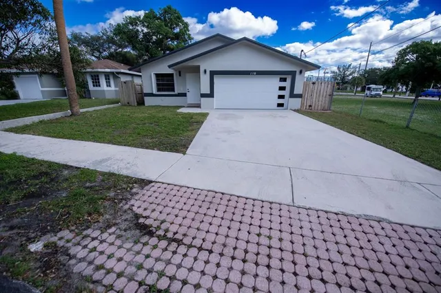 a front view of a house with a yard and trees