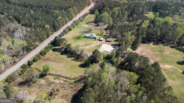 a aerial view of a house with a yard and large tree