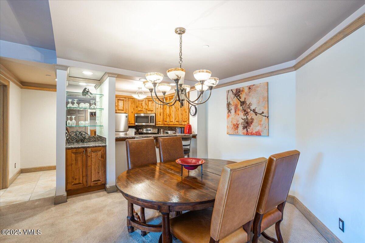 46 Avondale Lane, Unit R312 Beaver Creek, CO 81620 - Photo 16 of 47 a dining room with furniture a livingroom and chandelier