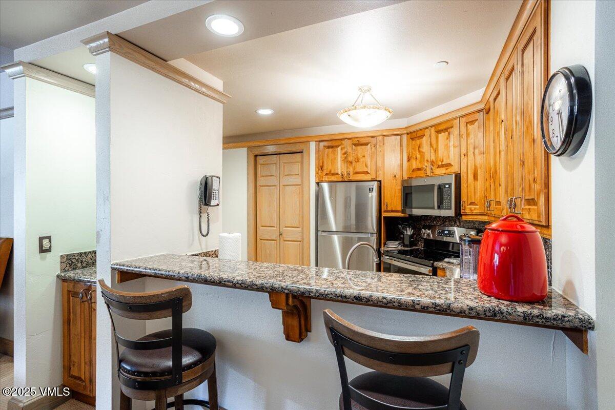 46 Avondale Lane, Unit R312 Beaver Creek, CO 81620 - Photo 17 of 47 a kitchen with stainless steel appliances granite countertop a sink a stove and chairs