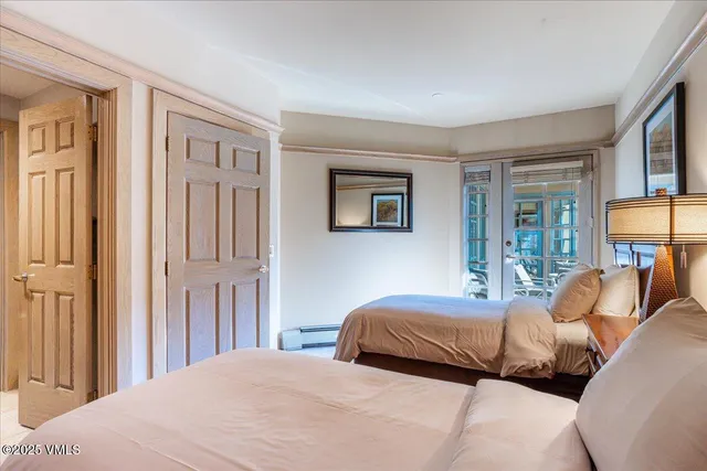 a bedroom with two beds and a large window