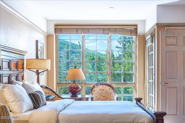 a bedroom with a bed and a large window with outer view