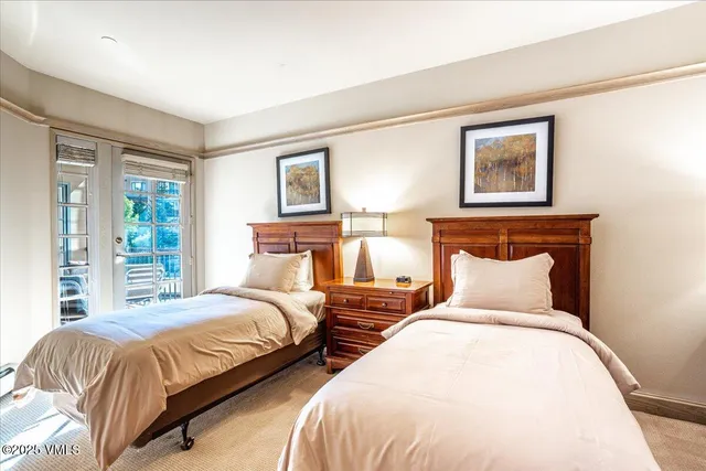 a bedroom with two beds and a night stand