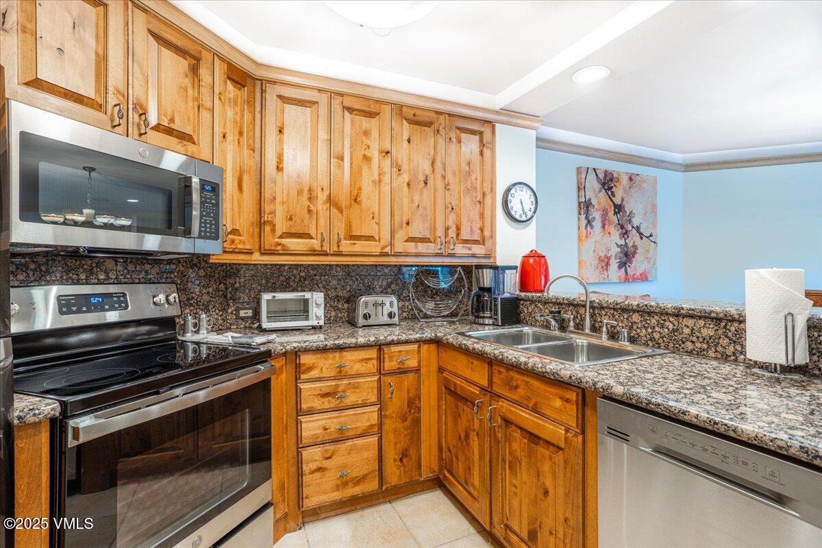 46 Avondale Lane, Unit R312 Beaver Creek, CO 81620 - Photo 10 of 47 a kitchen with stainless steel appliances granite countertop a stove a sink and a microwave