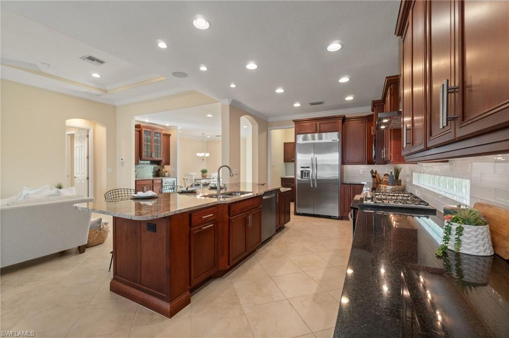 19753 Tesoro Way Estero, FL 33967 - Photo 3 of 47 a large kitchen with stainless steel appliances granite countertop a large counter top a stove and a sink