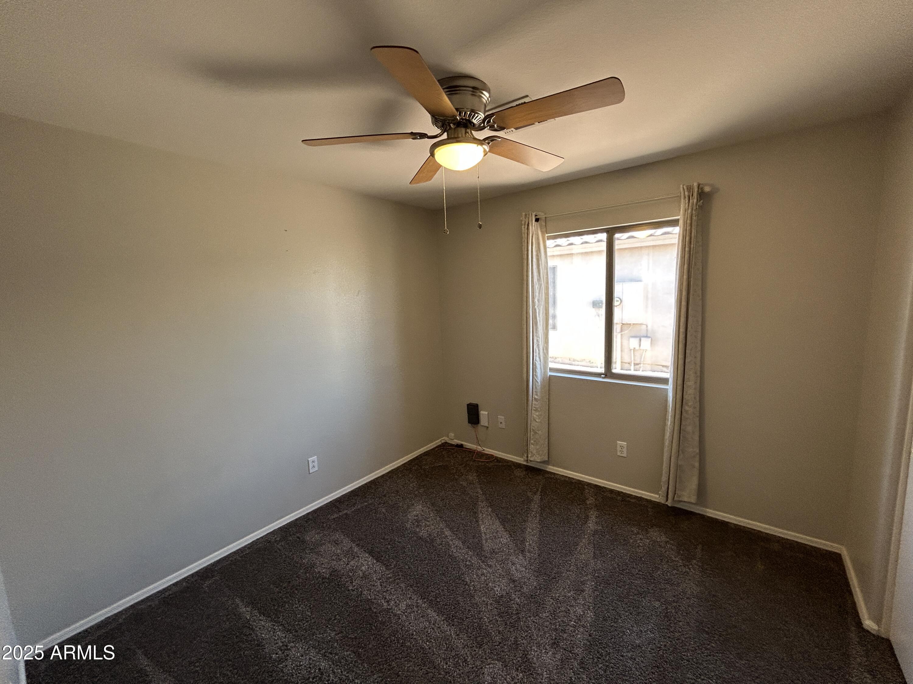 15011 West Redfield Road Surprise, AZ 85379 - Photo 12 of 16 an empty room with windows and fan