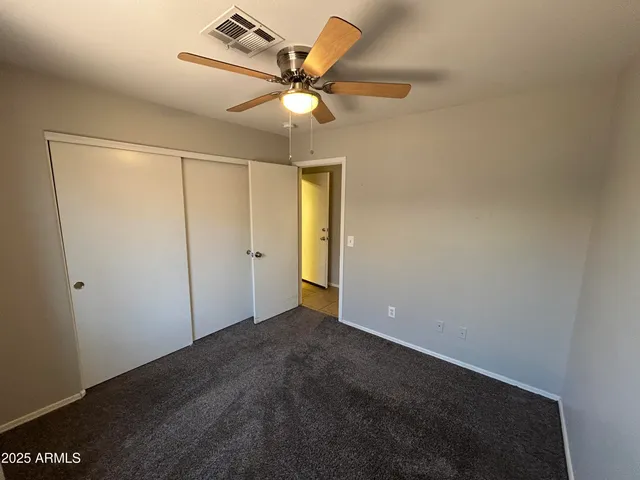an empty room with a ceiling fan and a window