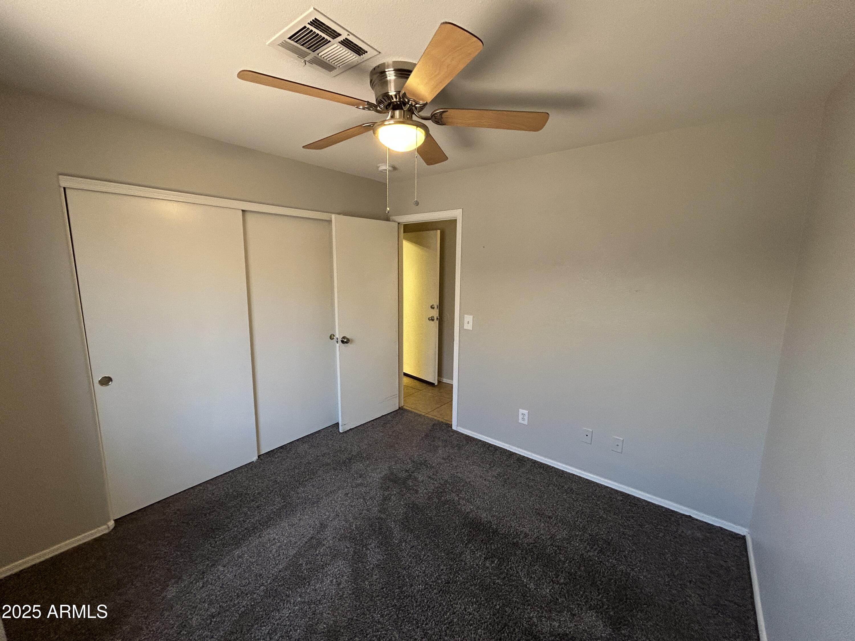15011 West Redfield Road Surprise, AZ 85379 - Photo 13 of 16 an empty room with a ceiling fan and a window