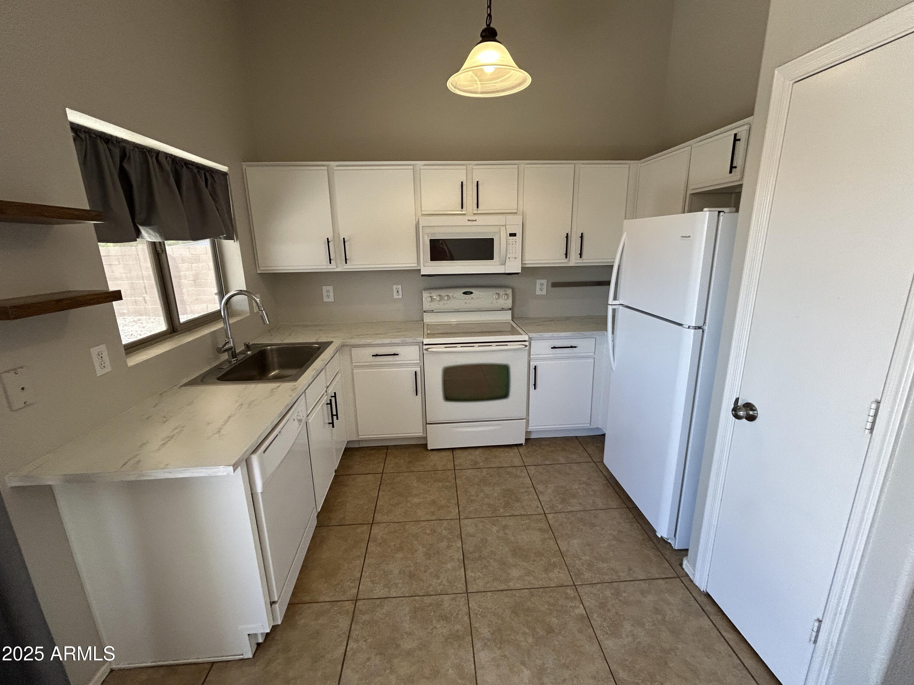 15011 West Redfield Road Surprise, AZ 85379 - Photo 5 of 16 a kitchen with a stove a refrigerator and a sink