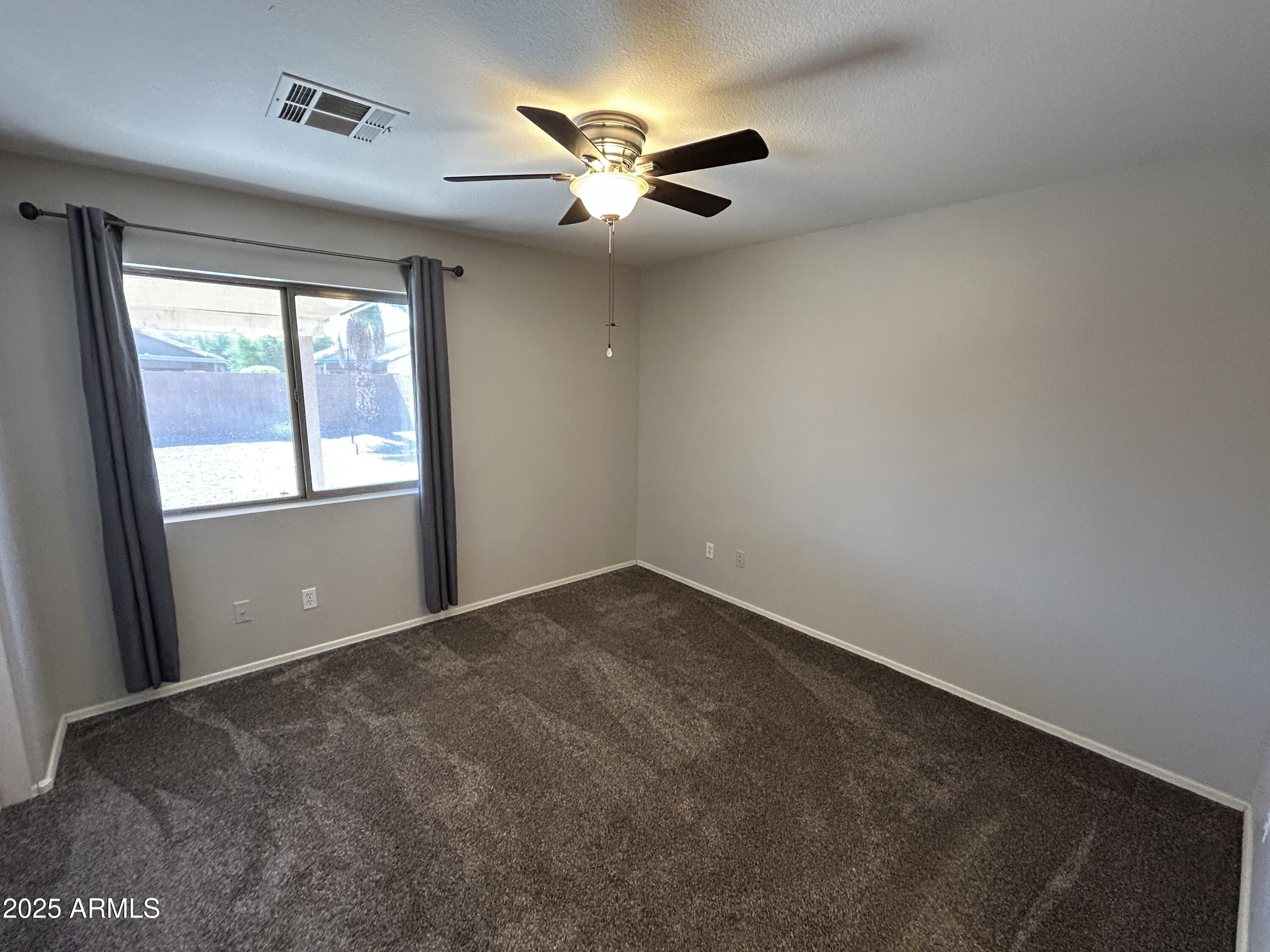 15011 West Redfield Road Surprise, AZ 85379 - Photo 7 of 16 an empty room with windows and ceiling fan