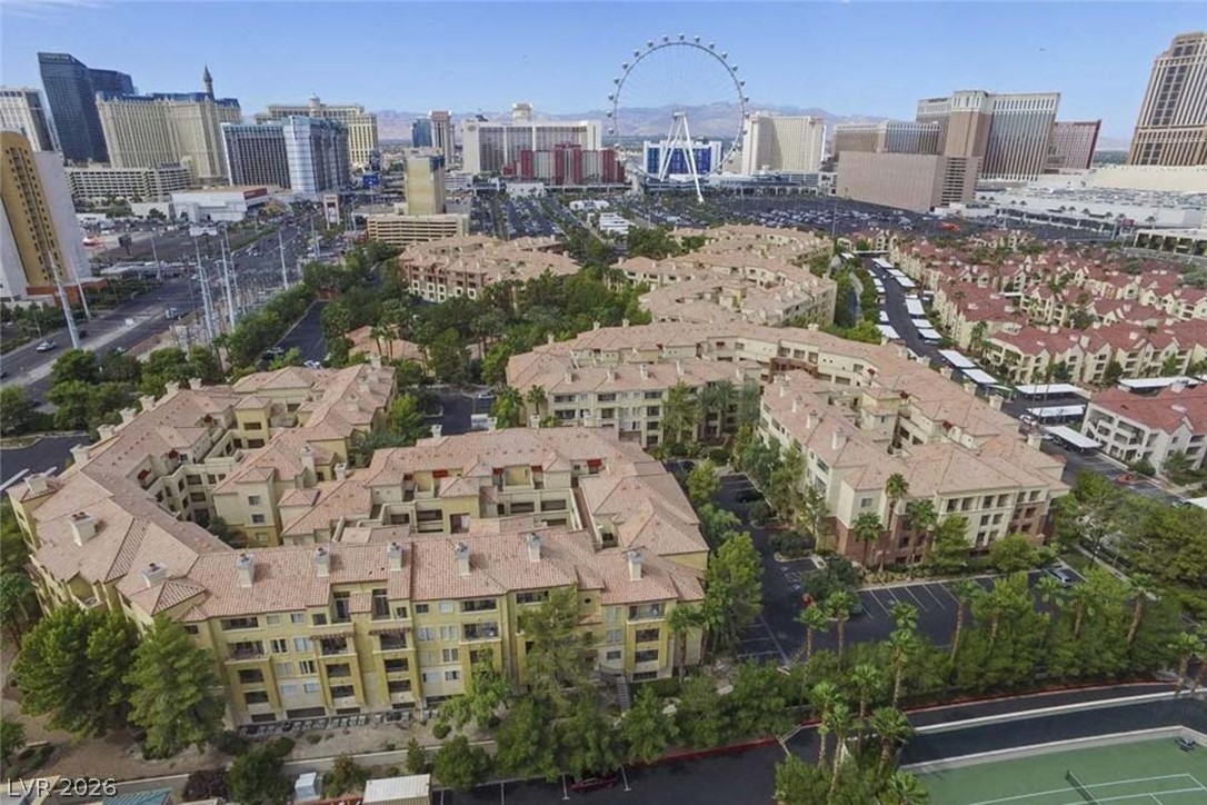 220 East Flamingo Road, Unit 305 Las Vegas, NV 89169 - Photo 22 of 26 An aerial perspective reveals a vibrant community with multi-story buildings, verdant landscaping, and distant city lights.