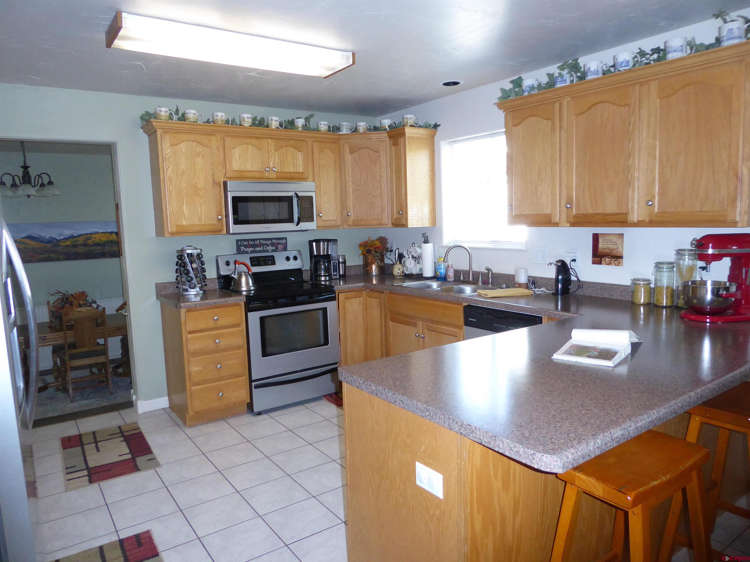 800 Northeast 2nd Street Cedaredge, CO 81413 - Photo 12 of 45 a kitchen with stainless steel appliances granite countertop a sink a stove top oven a counter space and cabinets