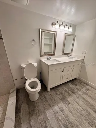 a bathroom with a toilet sink and mirror