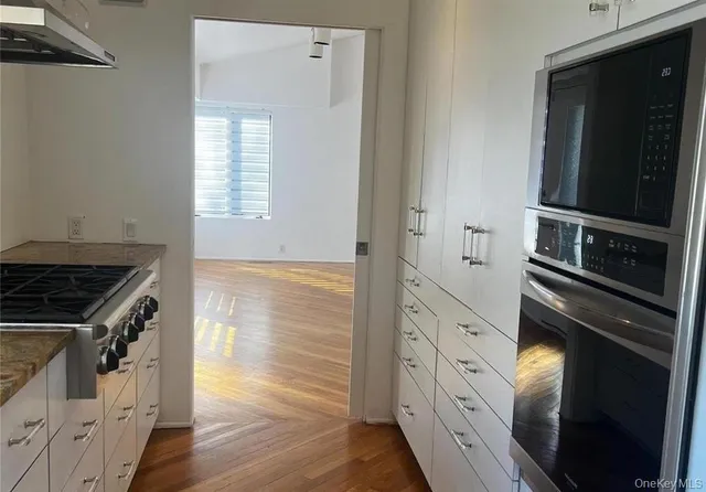 a kitchen with white cabinets and black appliances