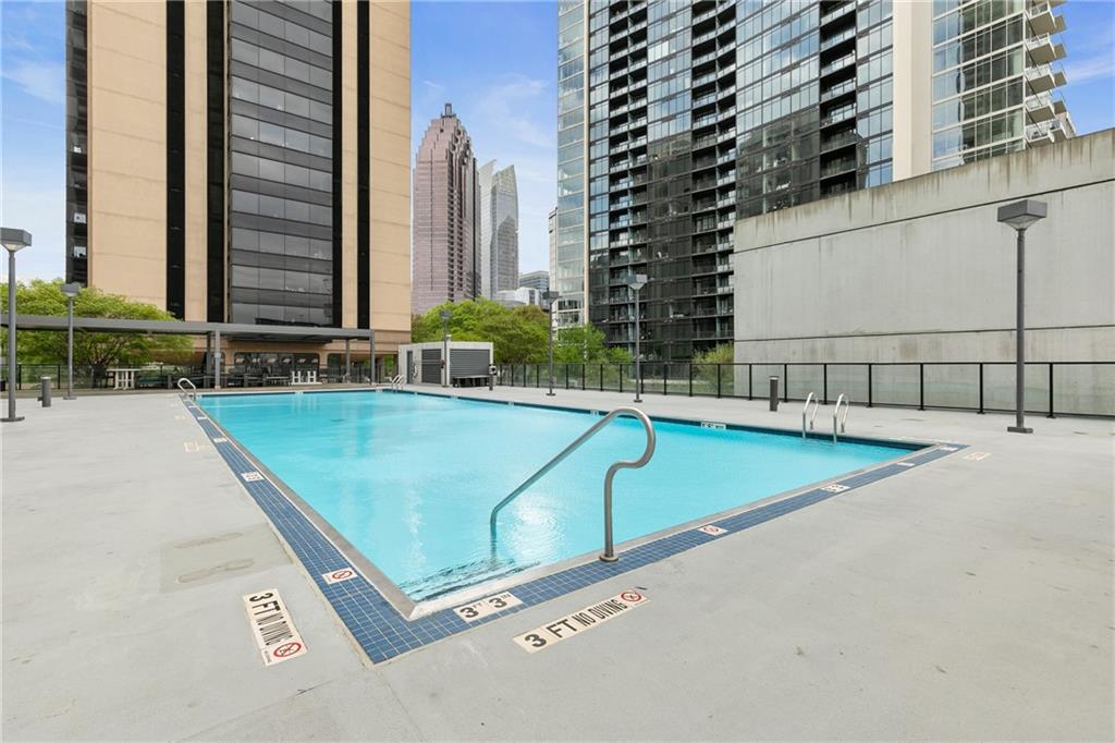 1280 West Peachtree Street Northwest, Unit 3806 Atlanta, GA 30309 - Photo 29 of 35 a view of a swimming pool with a lounge chair
