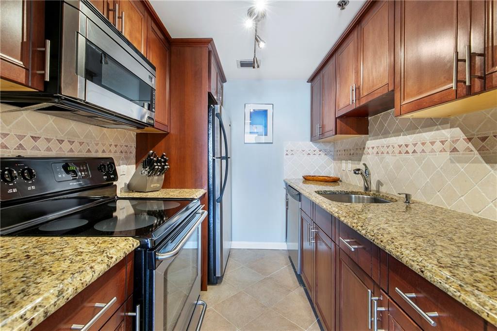 1280 West Peachtree Street Northwest, Unit 3806 Atlanta, GA 30309 - Photo 6 of 35 a kitchen with stainless steel appliances granite countertop a sink stove microwave and refrigerator