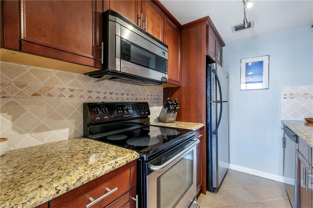 1280 West Peachtree Street Northwest, Unit 3806 Atlanta, GA 30309 - Photo 7 of 35 a kitchen with granite countertop a stove and a microwave