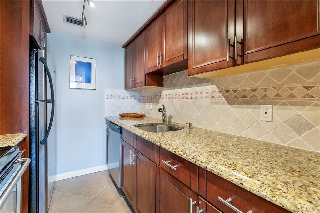 1280 West Peachtree Street Northwest, Unit 3806 Atlanta, GA 30309 - Photo 8 of 35 a kitchen with granite countertop stainless steel appliances and wooden cabinets
