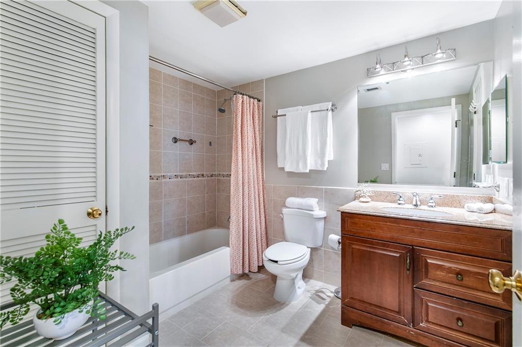 1280 West Peachtree Street Northwest, Unit 3806 Atlanta, GA 30309 - Photo 9 of 35 a bathroom with a granite countertop sink a toilet a mirror and shower