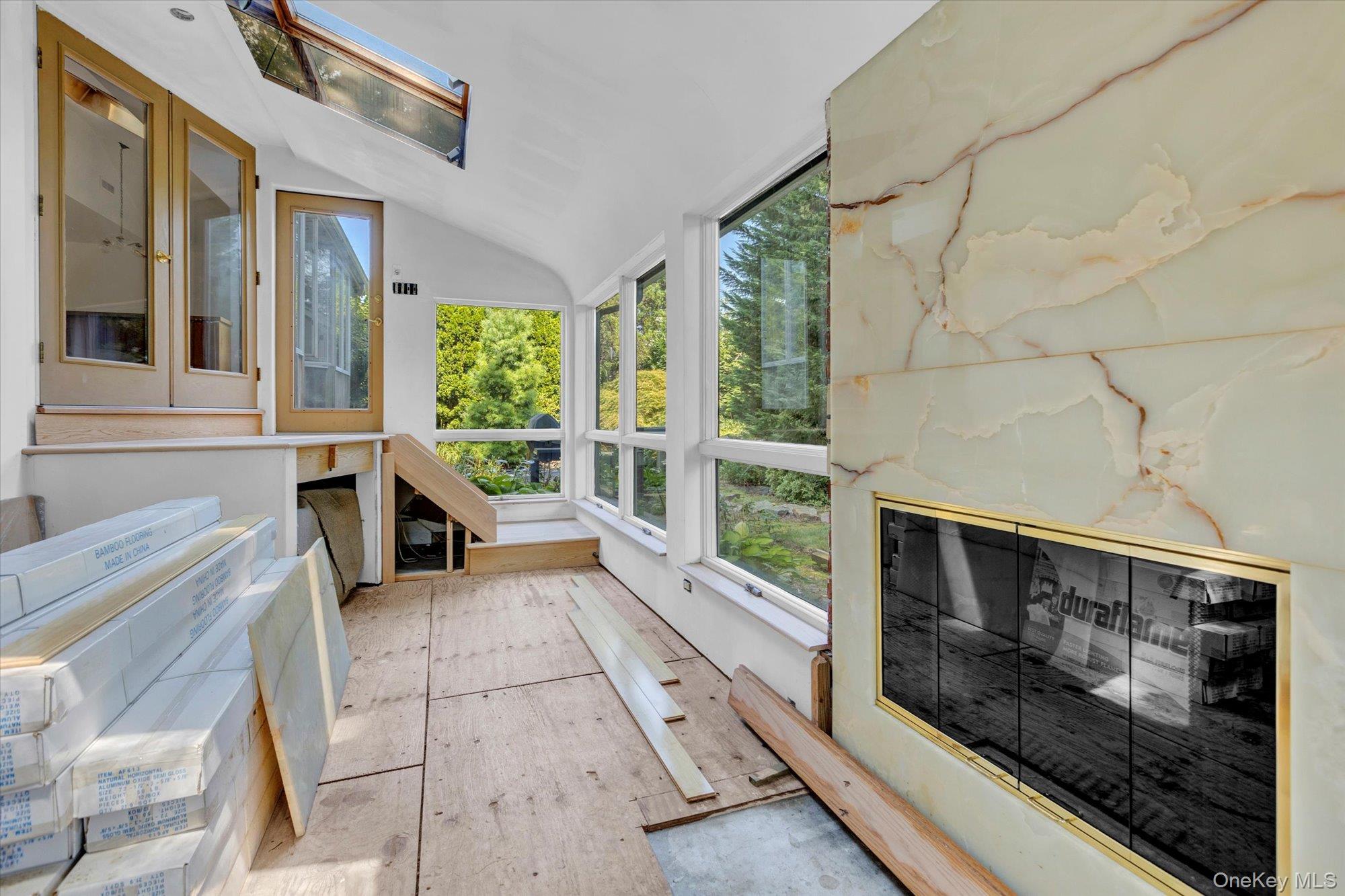 19 Clearland Road Syosset, NY 11791 - Photo 12 of 22 Unfurnished sunroom with a skylight, vaulted ceiling, and wood finished floors