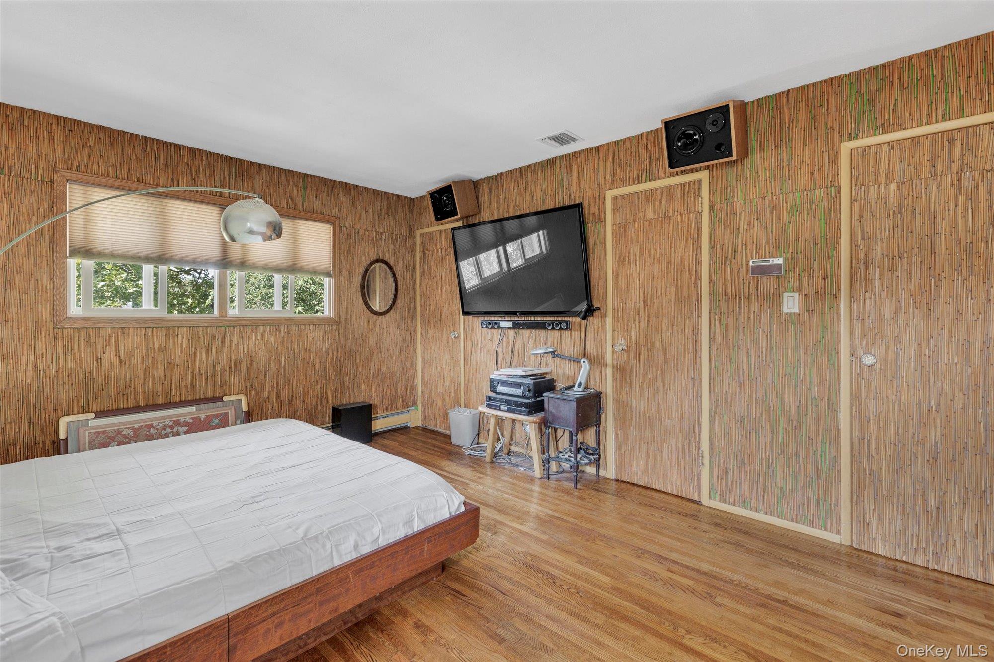 19 Clearland Road Syosset, NY 11791 - Photo 16 of 22 Bedroom with wood finished floors, wood walls, and baseboard heating