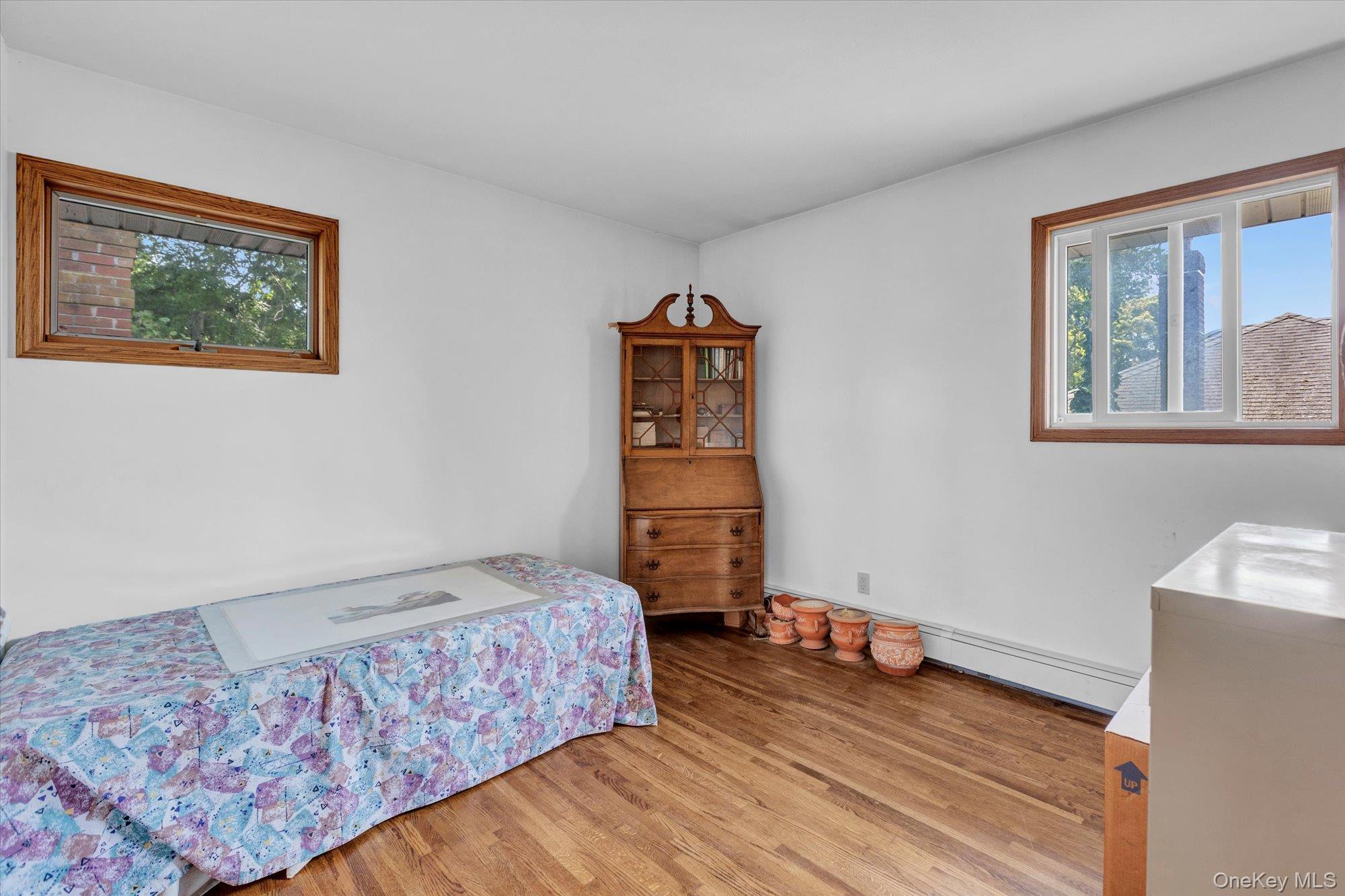 19 Clearland Road Syosset, NY 11791 - Photo 17 of 22 Bedroom with light wood-type flooring and a baseboard heating unit