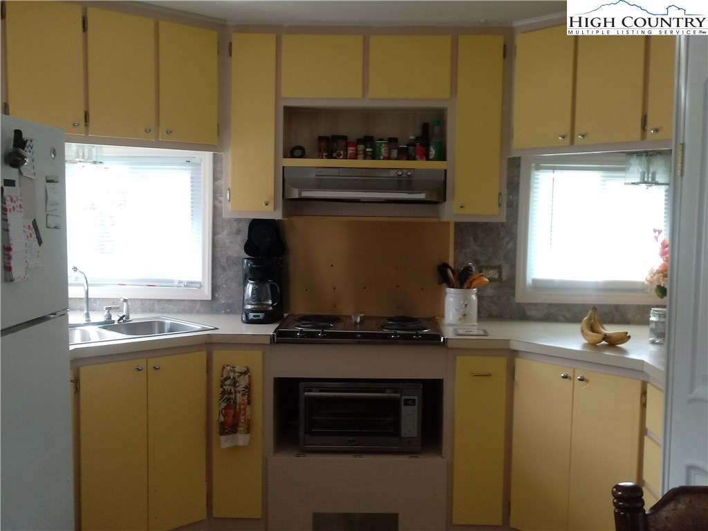2449 Old Barrett Road Ennice, NC 28623 - Photo 2 of 12 a kitchen with a stove a sink and a microwave