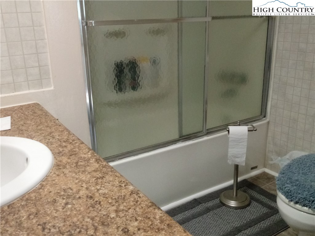 2449 Old Barrett Road Ennice, NC 28623 - Photo 6 of 12 a bathroom with a granite countertop shower and a sink