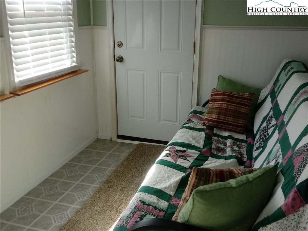 2449 Old Barrett Road Ennice, NC 28623 - Photo 7 of 12 a bed sitting in a room next to a window