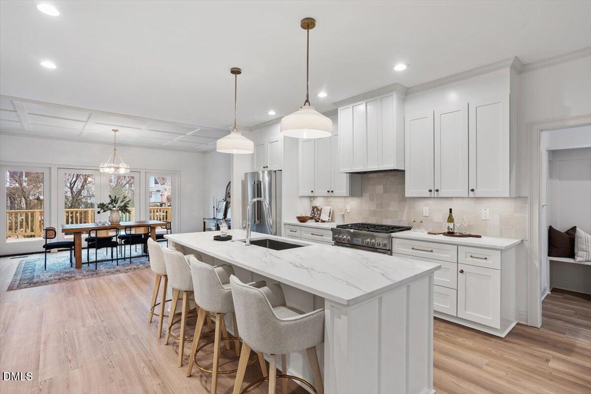 203 Baggett Avenue Raleigh, NC 27604 - Photo 12 of 52 a kitchen with a dining table chairs sink and cabinets