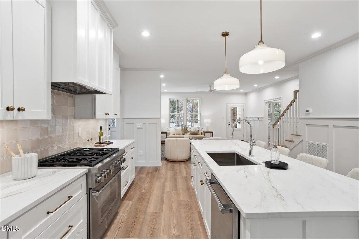 203 Baggett Avenue Raleigh, NC 27604 - Photo 14 of 51 a kitchen with counter top space a sink stainless steel appliances and cabinets