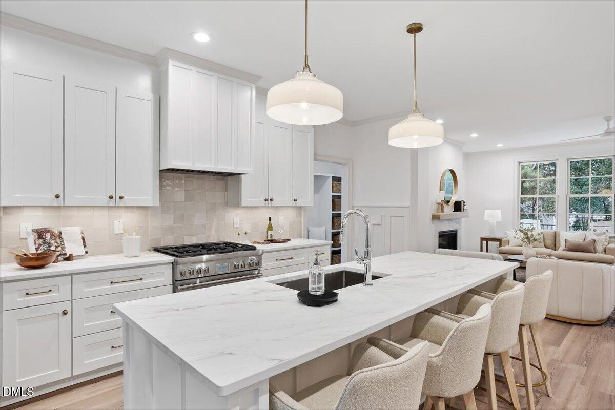 203 Baggett Avenue Raleigh, NC 27604 - Photo 14 of 52 a kitchen with a dining table chairs and white cabinets