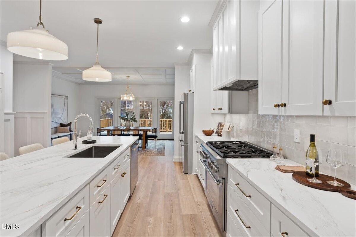 203 Baggett Avenue Raleigh, NC 27604 - Photo 17 of 51 a kitchen with kitchen island granite countertop a sink a stove and cabinets
