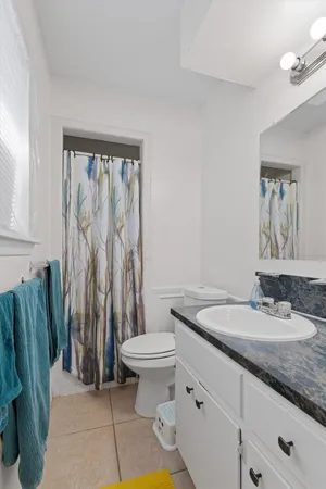 a bathroom with a granite countertop sink a toilet and a mirror