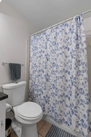 a white toilet sitting next to a shower curtain