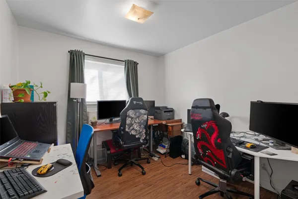 a view of a workspace with furniture and wooden floor