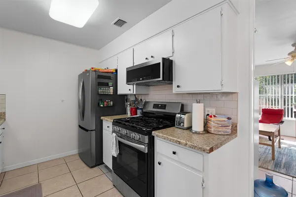 a kitchen with stainless steel appliances granite countertop a stove a sink and a refrigerator