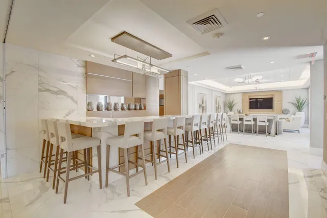 a dining area with stainless steel appliances lots of white furniture a dining table and chairs